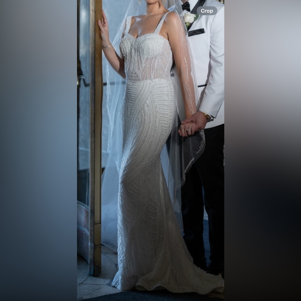 Very beaded, pure white wedding dressss with detachable skirt.